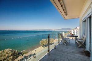 balcone con tavolo, sedie e vista sull'oceano di Designer's Apartment a Perea