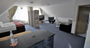 ein Hotelzimmer mit Bett und Wohnzimmer in der Unterkunft Hotel Leo Mühlhausen in Mühlhausen