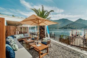 patio con divano e ombrellone di Boutique Hotel & Spa Casa del Mare - Mediterraneo a Herceg-Novi