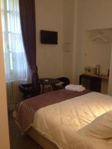 1 dormitorio con cama, mesa y TV en Ida Chambres d'hôtes B&B, en Montpellier