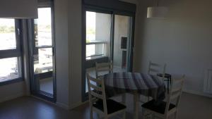 - une salle à manger avec une table, des chaises et des fenêtres dans l'établissement Departamento Villegas, à Coronel Suárez