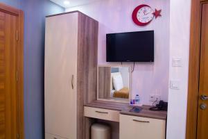 a room with a mirror and a tv on a wall at Figen Hotel in Çanakkale