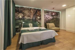 a bedroom with a bed with a large painting on the wall at Hotel Ciudad del Mar in Las Palmas de Gran Canaria