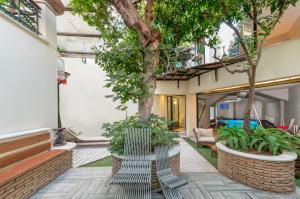a patio with trees and chairs in a house at Kallimarmaro Residence in Athens