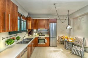 a kitchen with wooden cabinets and a stainless steel refrigerator at Kallimarmaro Residence in Athens