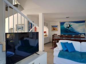a living room with a white couch and a tv at Villa COCONUT GROVE in Ramsgate