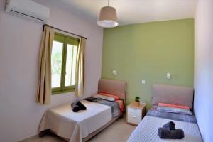a bedroom with two beds and a window at Vanna's Apartments in Leonidion