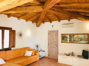 a living room with a couch and wooden ceilings at Villa vista mare con piscina in San Teodoro