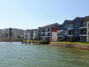 a row of apartment buildings next to a river at Laguna Grove Holiday Rentals in Knysna