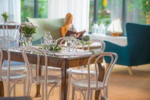 einen Tisch und Stühle mit Weingläsern und eine Frau in der Unterkunft Ośrodek Wypoczynkowo-Rehabilitacyjny "Bryza" in Dźwirzyno