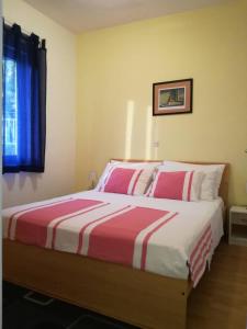 a bedroom with a large bed with pink and white sheets at House Zara in Maslenica