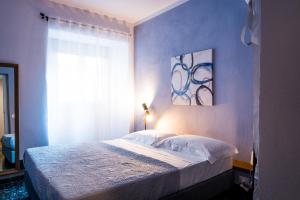 una camera con un letto con una parete blu di 5 Terre Inn Affittacamere a La Spezia