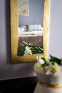 a mirror reflection of a bedroom with a bed and a plant at 5 Terre Inn Affittacamere in La Spezia