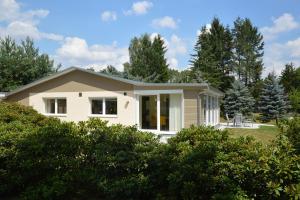 a small white house with trees in the background at Ferienquartier Goethe33 in Dresden