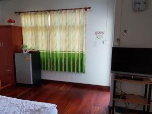 a room with a green curtain and a television at Greenhouse resort in Buriram