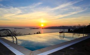 格洛萨Villa Malena的以日落为背景的游泳池