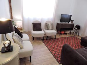 un soggiorno con divano, sedie e TV di BLISS WHITE HOUSE a Sintra