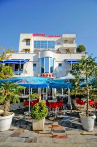 een hotel met tafels en stoelen voor een gebouw bij Hotel Lubjana in Tirana