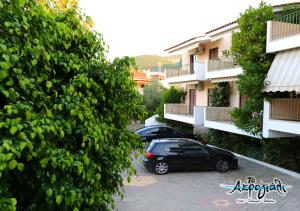 two cars parked in a parking lot in front of buildings at Akrogiali Hotel Restaurant in Xiropigado