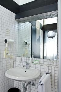 Baño blanco con lavabo y espejo en Hotel Paffhausen, en Wirges