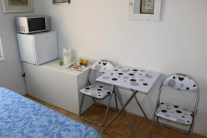 a small kitchen with a small table and two chairs at Rooms Vukovarska in Zagreb