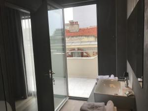 a bathroom with a sink and a glass door at Superior One Boutique Hotel in Thessaloniki