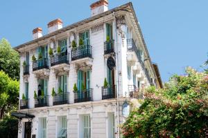 ein weißes Gebäude mit Fenstern und Balkonen in der Unterkunft Hotel Villa Rivoli in Nizza