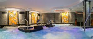 a hotel room with a hot tub with blue water at Hotel Princesa Parc in Arinsal