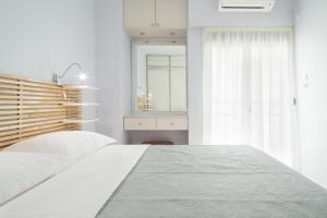 Habitación blanca con cama y espejo en Nephiria, Live like a local next to Acropolis! en Athens