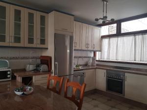 eine Küche mit weißen Schränken und einem Tisch und Stühlen in der Unterkunft Bungalows Bahamas beside the park and 300m to the beach in Puerto Rico de Gran Canaria + 13 Fotos