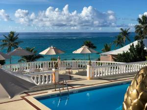 a resort swimming pool with the ocean in the background at Coco Reef Bermuda in Mount Pleasant