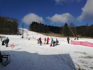 un gruppo di persone su una pista da sci coperta da neve di Pension Druhý domov a Nový Bor