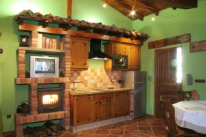a kitchen with a fireplace in the center of the room at Casas Rurales Prieto in Cortes