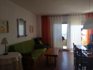 a living room with a green couch and a table at Apartamento Florazar 2, 8ºC in Cullera