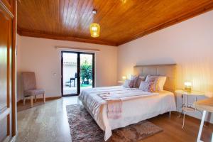 um quarto com uma cama grande e um tecto em madeira em Casa do Casalinho em Avelar