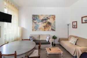 een woonkamer met een tafel en een bank bij Milano Homey Apartment in Milaan