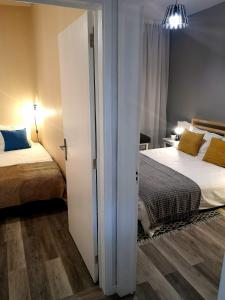 フンシャルにあるApartment Madeira Happinessのベッドルーム1室(ベッド2台付)、スライドドアが備わります。