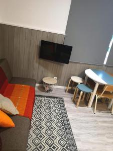 a living room with a couch and a table and a tv at Apartment Madeira Happiness in Funchal