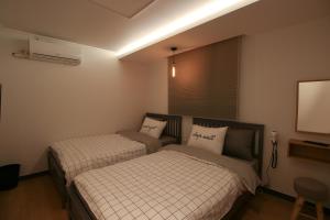 a bedroom with two beds and a tv at Heima Guesthouse Hongdae in Seoul