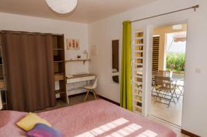 Schlafzimmer mit einem Bett, einem Schreibtisch und einem Tisch in der Unterkunft Fleur de canne in Sainte-Rose