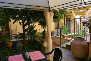 d'une terrasse avec une table, des chaises et un vase. dans l'établissement B&B Il Melograno Antico con Terrazza e Giardino, à Agrigente