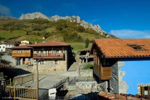 eine Gruppe von Gebäuden mit einem Berg im Hintergrund in der Unterkunft Casas Rurales Prieto in Cortes