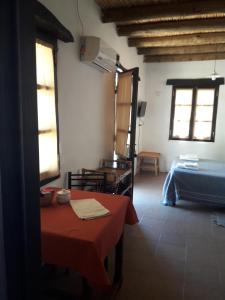 una habitación con una mesa y una cama en ella en cabañas Yamasu Huasi en Cafayate