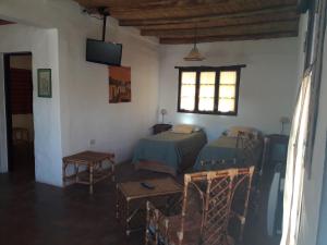 a living room with two beds and a window at cabañas Yamasu Huasi in Cafayate
