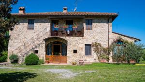 AcquavivaにあるLa Casa del Contadinoのポーチとバルコニー付きの古い石造りの家