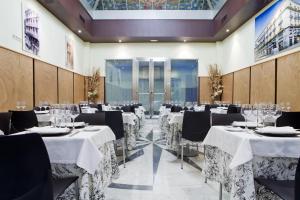 un salón de banquetes con mesas y sillas con manteles blancos en Hotel Europa, en Madrid