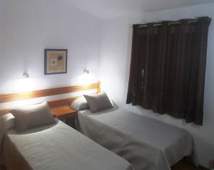 una camera d'albergo con due letti e una finestra di Palmeral PaMi ad Agaete