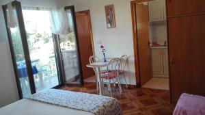 Habitación con mesa, silla y cocina. en Apartment Mirjana, en Bibinje
