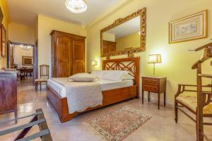 a bedroom with a bed with a mirror and a chair at B & B La Fontaine Residenza D'Epoca in Viterbo