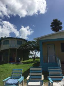eine Gruppe von Stühlen, die vor einem Haus sitzen in der Unterkunft Waikiki Guest House in Treasure Beach